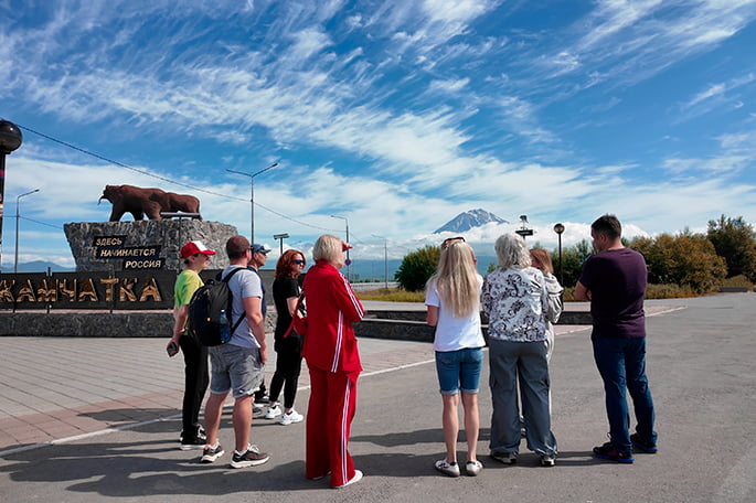 экскурсовод у памятника с медведями